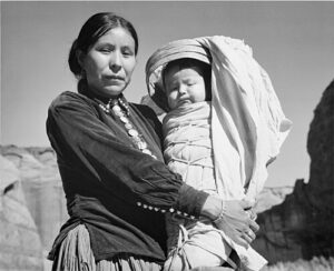 Diné culture Navajo Woman and Infant, Canyon de Chelle, Arizona (Canyon de Chelly National Monument), 1933 - 1942 - NARA - Photo: Ansel Adams. Public Domain
